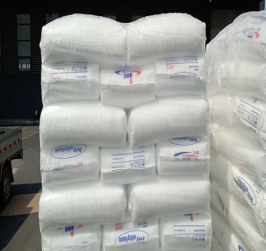 Full-pallet-stacked-bulk-stock-of-LOPC-BPC-HDPE-plastic-resin-sacks-warehouse-outdoor-storage